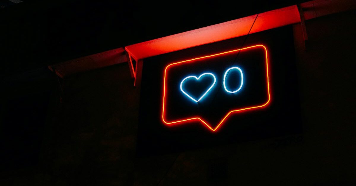 Neon sign illuminated with a red box and a heart and zero inside in blue